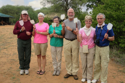 thomson safaris guests holding fly swatters for tse tse