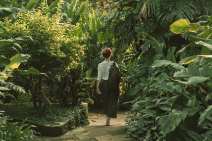 woman walks through lush greenery at gibbs farm