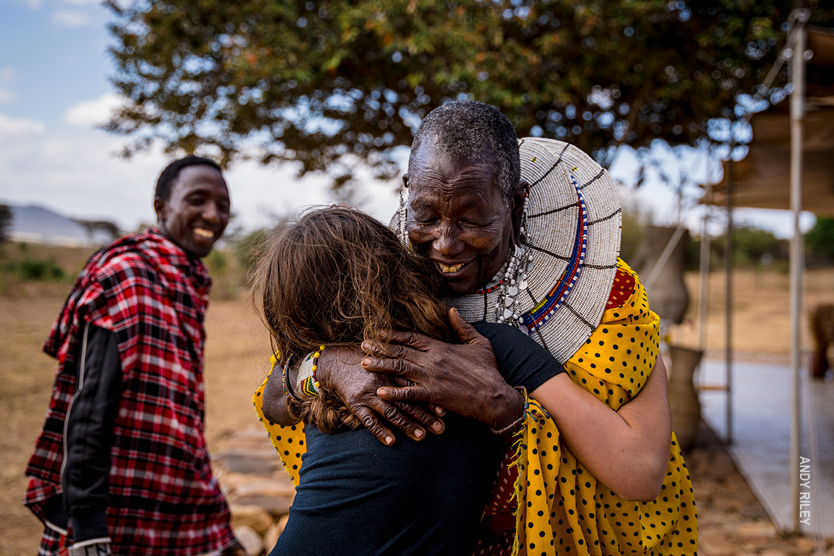 girl hugs maasai woman on family safari in tanzania