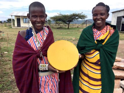 maasai women with beeswax wheel in tanzania