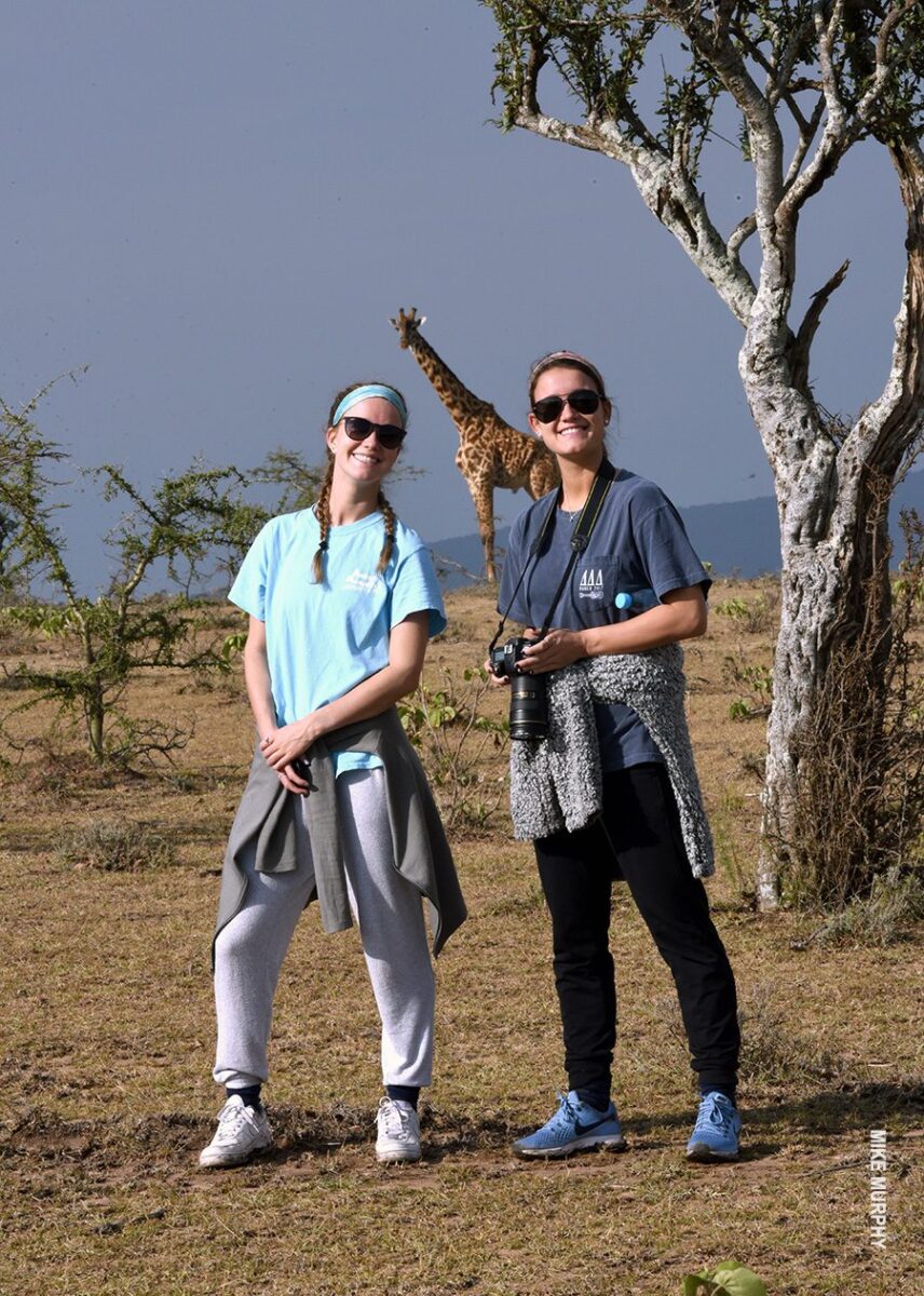 teenage girls on walking safari with giraffe