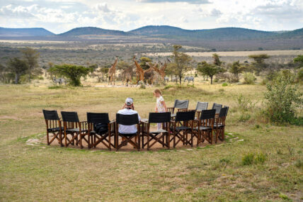 family watching giraffes at waterhole at thomson nyumba camp