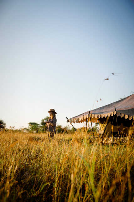 woman drinking coffee at thomson nyumba tent in serengeti