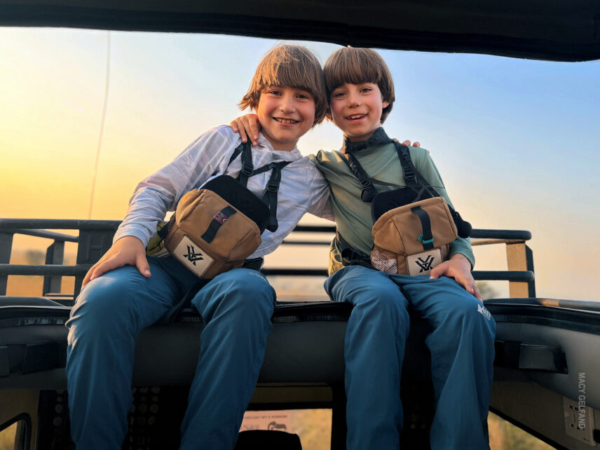 boys on family safari smiling in their vehicle in the serengeti