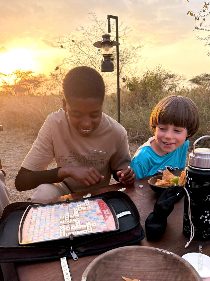 boy playing scrabble with thomson rafiki at camp on a family safari