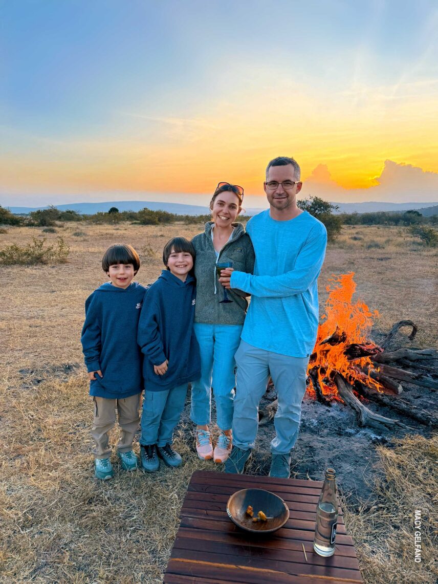 family at campfire with sundowner drinks and snacks at eastern serengeti nyumba camp