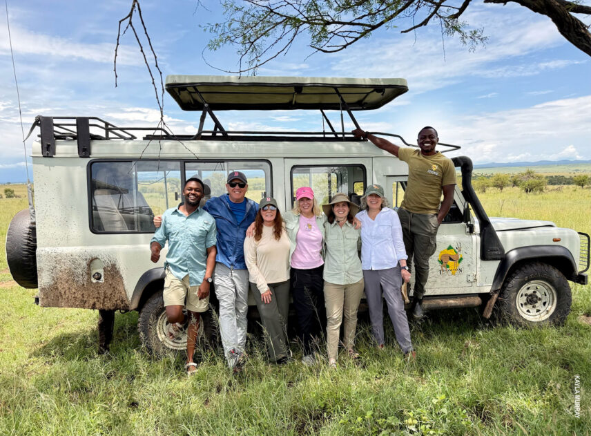 thomson safaris group poses in front of safari vehicle in serengeti