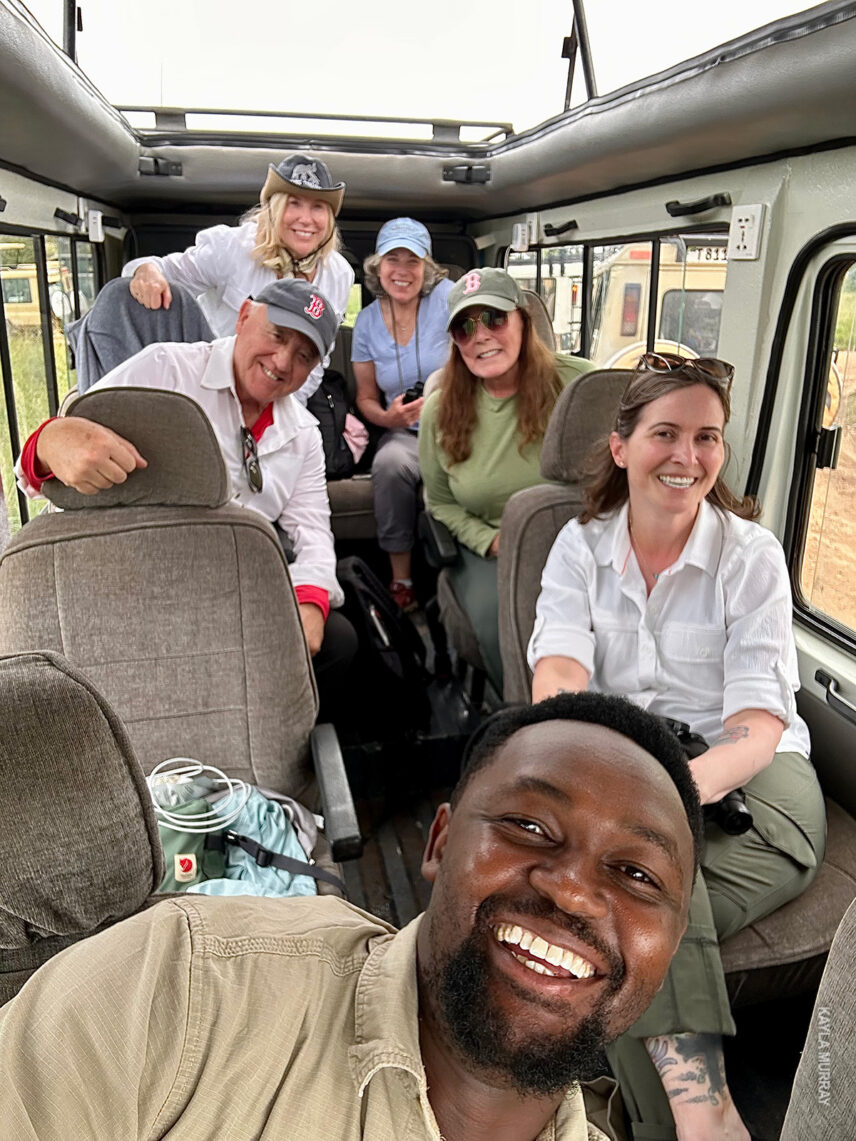 guide dickson takes a selfie with thomson safaris guests inside the vehicle